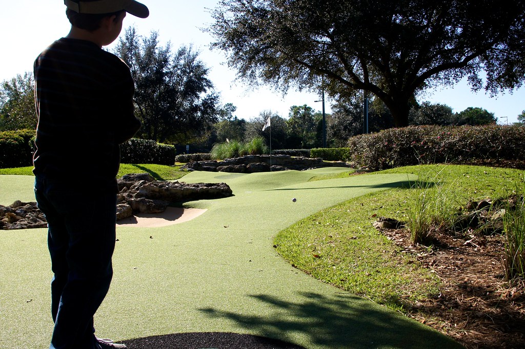 child playing minature golf