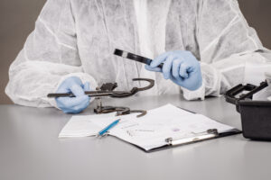 Handcuffs being tested by a scientist with blue gloves on 
