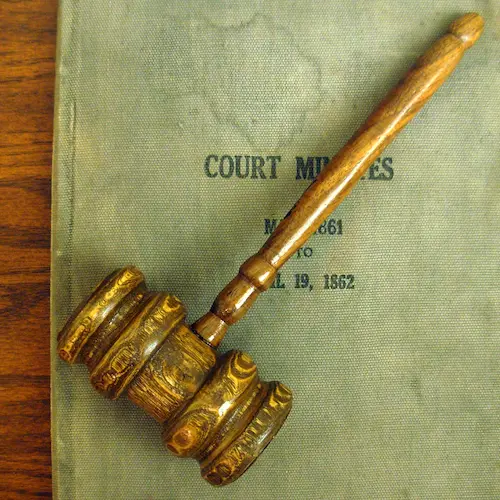 Photo of a wooden court gavel on top of a legal book